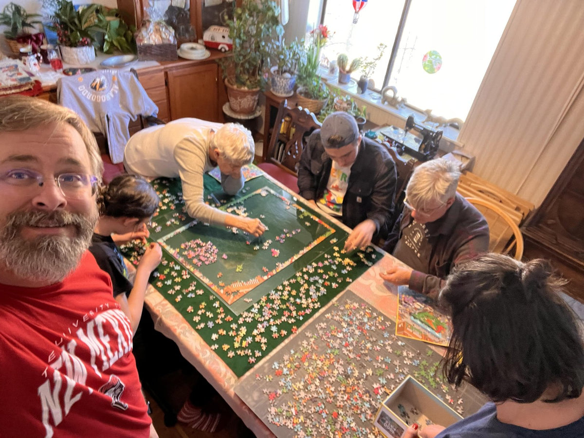 Kid, parent and grandparent hands reaching into the same puzzle
