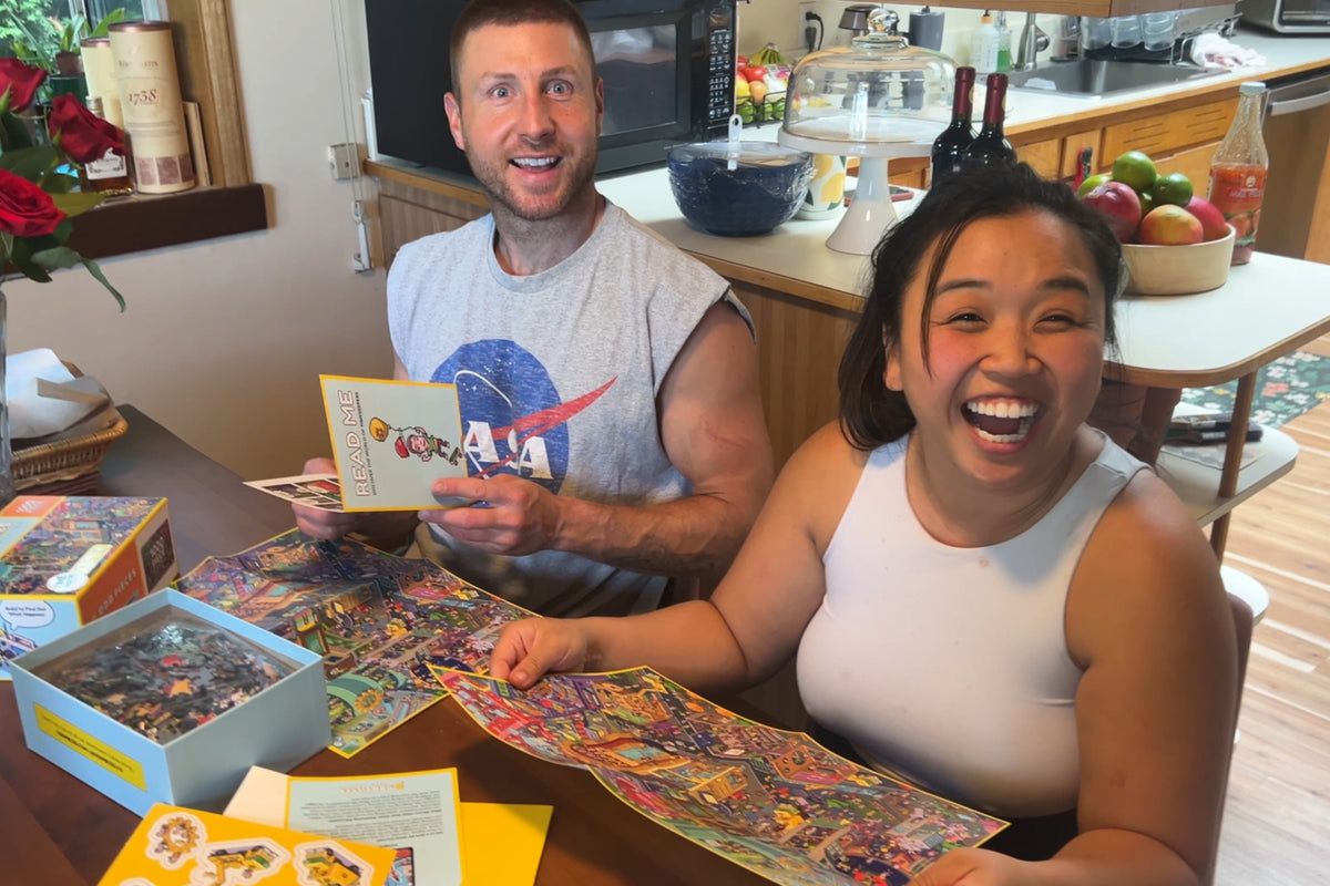 Two mugs and two pairs of hands on a half-built puzzle